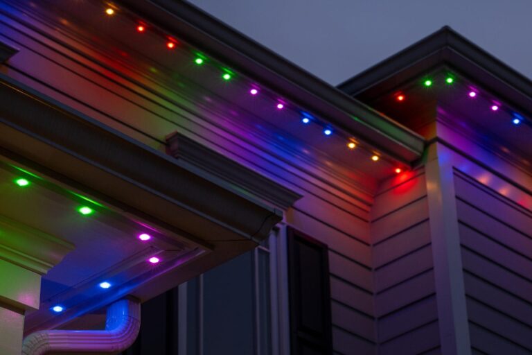 A home exterior with Oelo rainbow lighting in red, green, yellow, blue, and purple, demonstrating vibrant, customizable designs.
